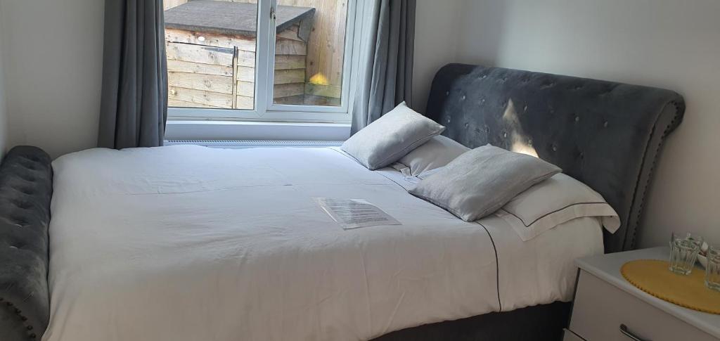 uma cama num quarto com uma janela em Peaceful time em Trowbridge