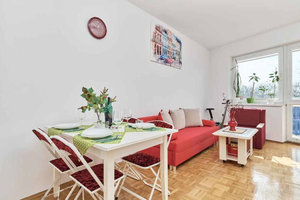 a living room with a red couch and a table at Apartments Wrocław Legnicka by Renters in Wrocław