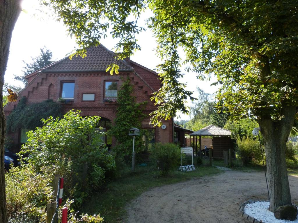 una casa de ladrillo con un árbol delante de ella en Haus Elbtalaue, en Bleckede