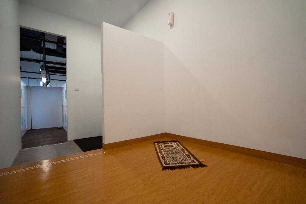 an empty room with a rug on a wooden floor at Bobopod Kota Tua, Jakarta in Jakarta