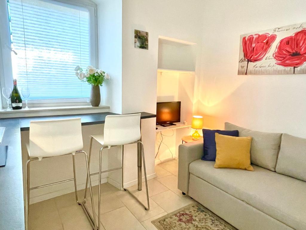Happy Casa Isola Piccola في إيزولا: غرفة معيشة مع أريكة وطاولة وكراسي
