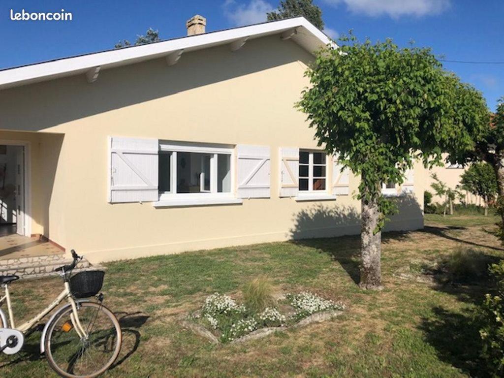 un vélo garé devant une maison dans l'établissement Villa Maléal, Grande maison de vacance à Soulac sur Mer, à Soulac-sur-Mer