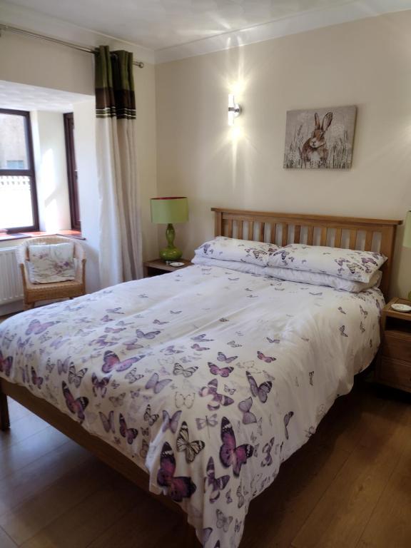 um quarto com uma cama com um edredão floral em The Denes em Mablethorpe