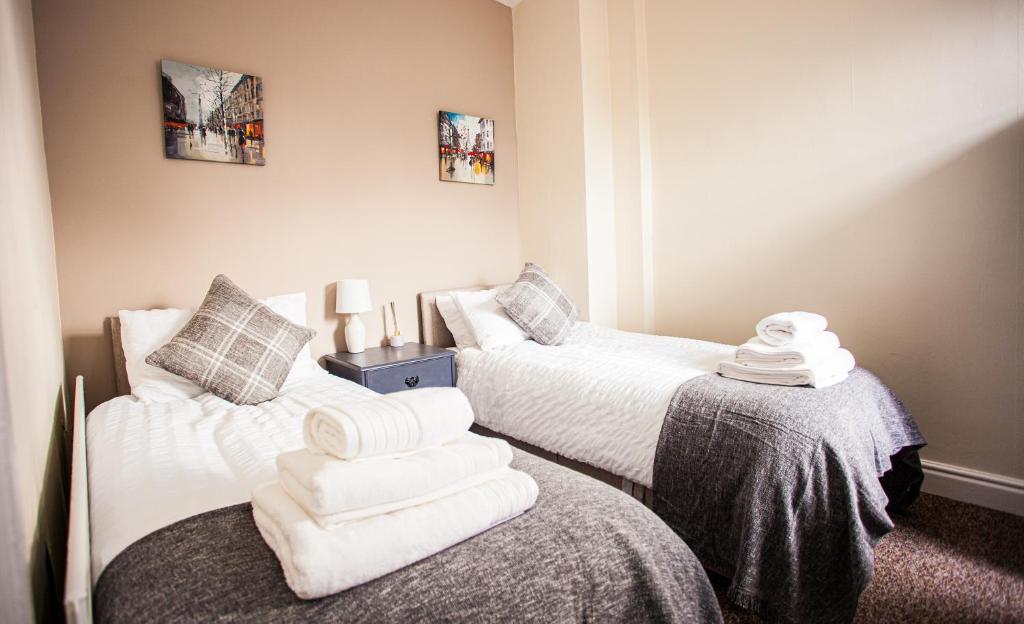 - 2 lits dans une chambre avec des serviettes sur le lit dans l'établissement Contractor house, sleeps 5, close to restaurant's and bars, Long stays available, Oveyo Accommodation, à Middlesbrough