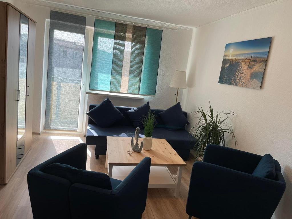 ein Wohnzimmer mit einem blauen Sofa und einem Tisch in der Unterkunft TOP Lage in Rostock 3 Zimmer Wohnung mit bestem Ausblick im 1 OG rechts in Rostock