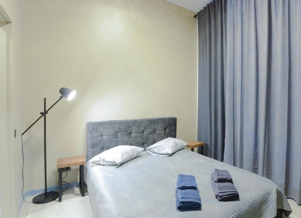 a bedroom with a bed with two towels on it at Pasta Amber Lux in Liepāja