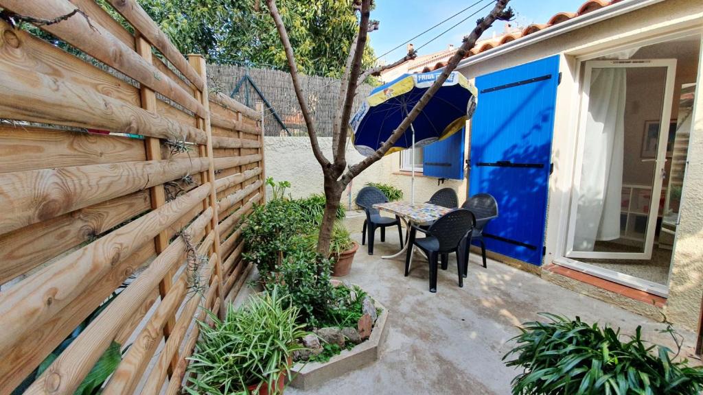 une terrasse avec une clôture et une table avec un parasol dans l'établissement Studio charmant à Banyuls-sur-Mer, 30 m², avec terrasse, à Banyuls-sur-Mer