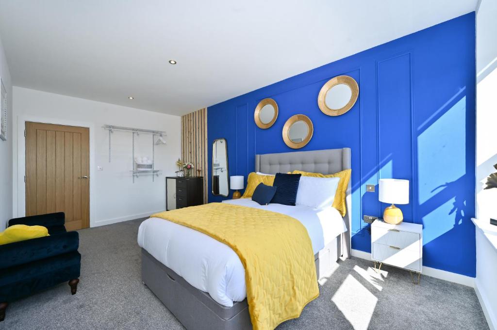 a blue bedroom with a bed and a blue wall at Spacious Designer 2BR Executive Apt, Near Beach & Marina, Central Location in Kent