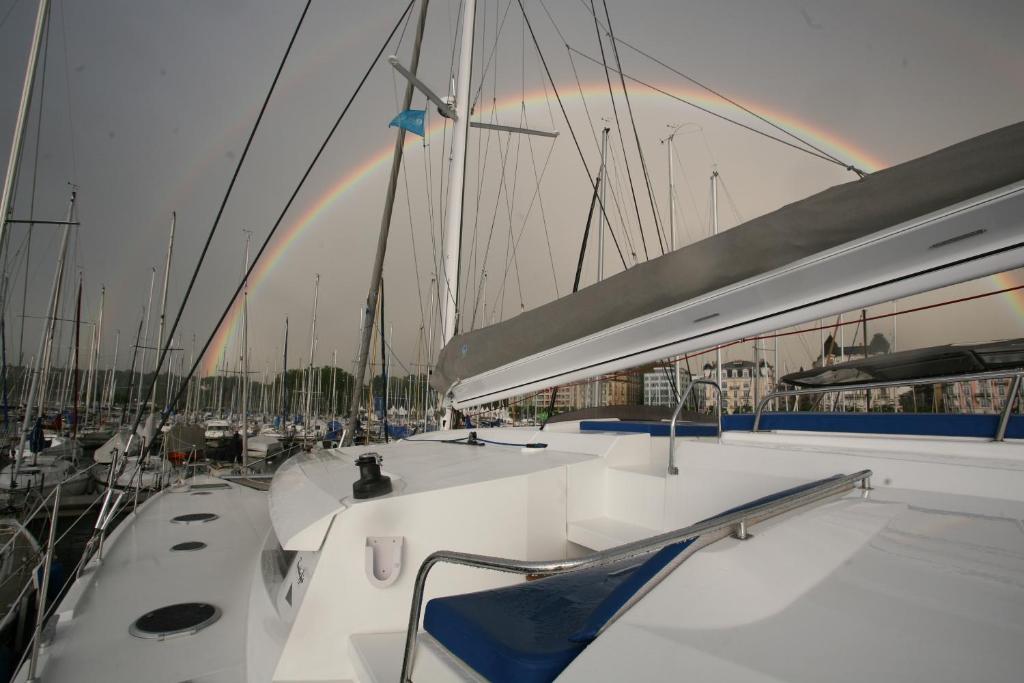 a bunch of boats parked in a harbor with a rainbow at Floatinn Boat-BnB in Geneva
