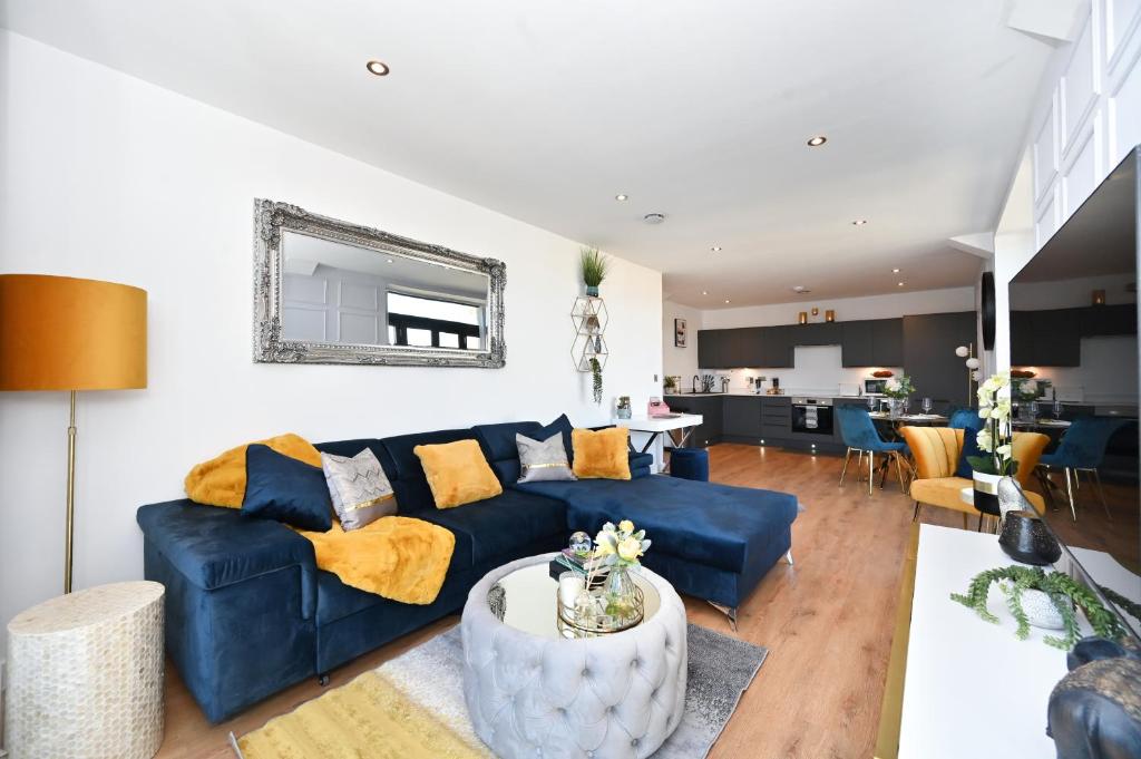 ein Wohnzimmer mit einem blauen Sofa und einem Tisch in der Unterkunft Spacious Designer 2BR Executive Apt, Near Beach & Marina, Central Location in Kent