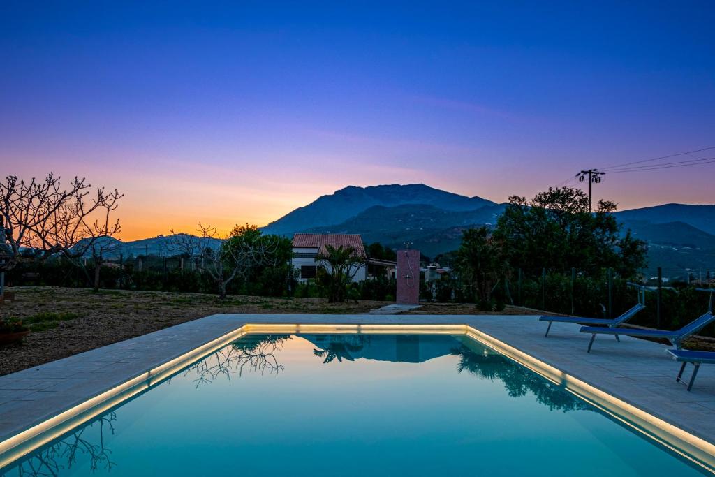 a swimming pool with a view of the mountains at Scialari Country House in Castellammare del Golfo