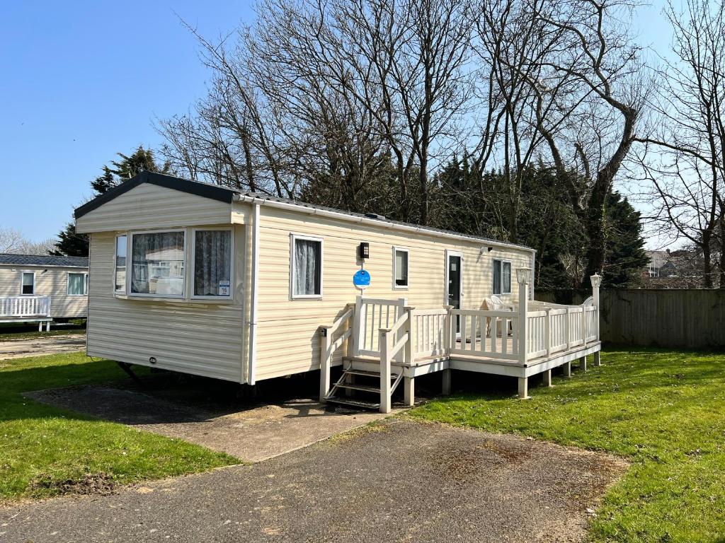 a small white trailer parked in a yard at 2 Bedroom Caravan NV16, Lower Hyde, Shanklin, Isle of Wight in Shanklin