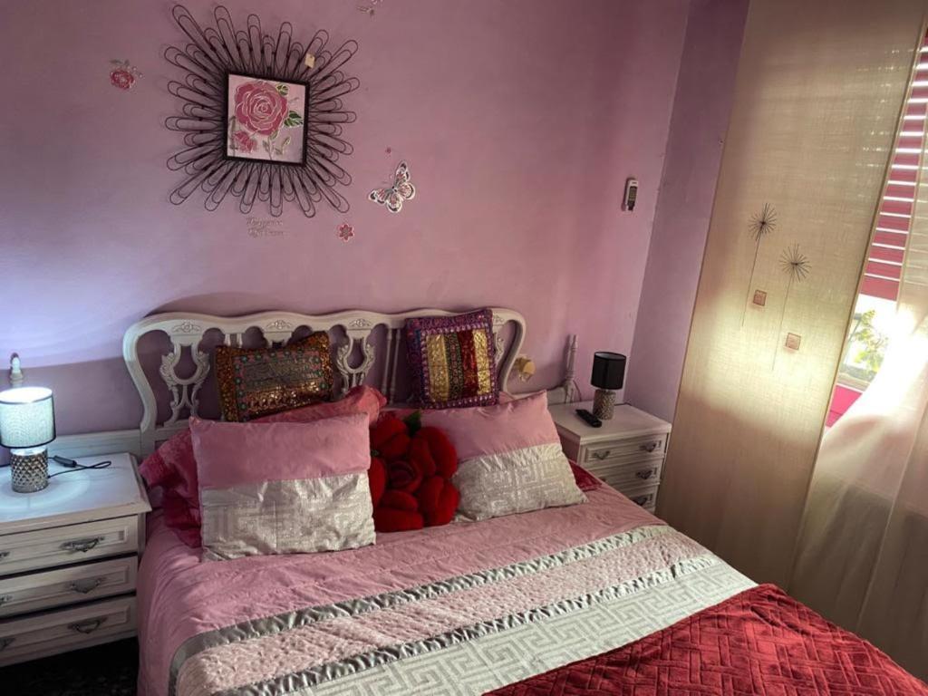 a bedroom with a bed with pink walls at Vicky apart in Calafell