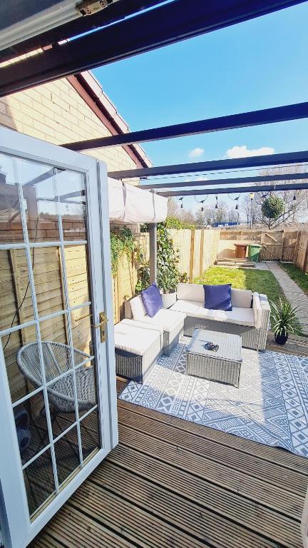 a patio with couches and a table and a glass door at Beautiful 2bed house with garden, walking distance to town - FREE parking in Glasgow