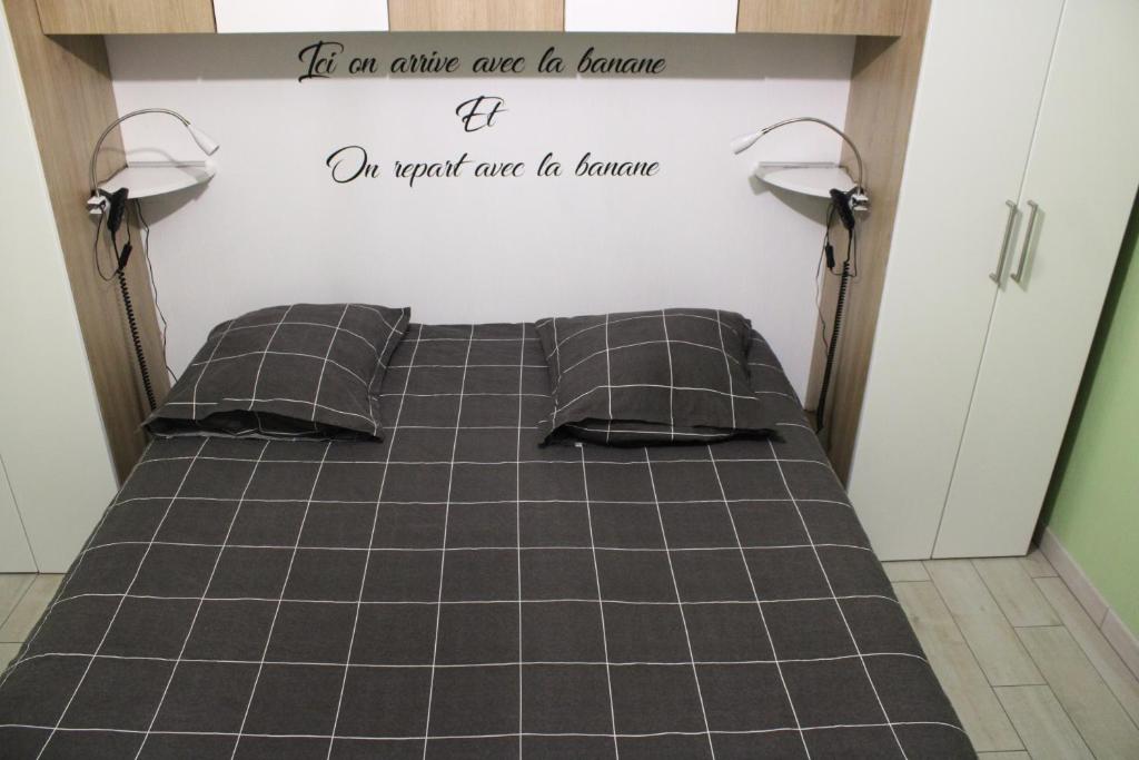 - un lit dans une chambre avec un panneau mural dans l'établissement L'Escale, chambres chez l'habitant, au Mans