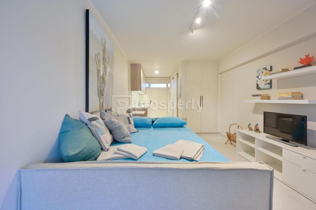 een groot bed met blauwe kussens in een kamer bij Sophia's studio in Saronida