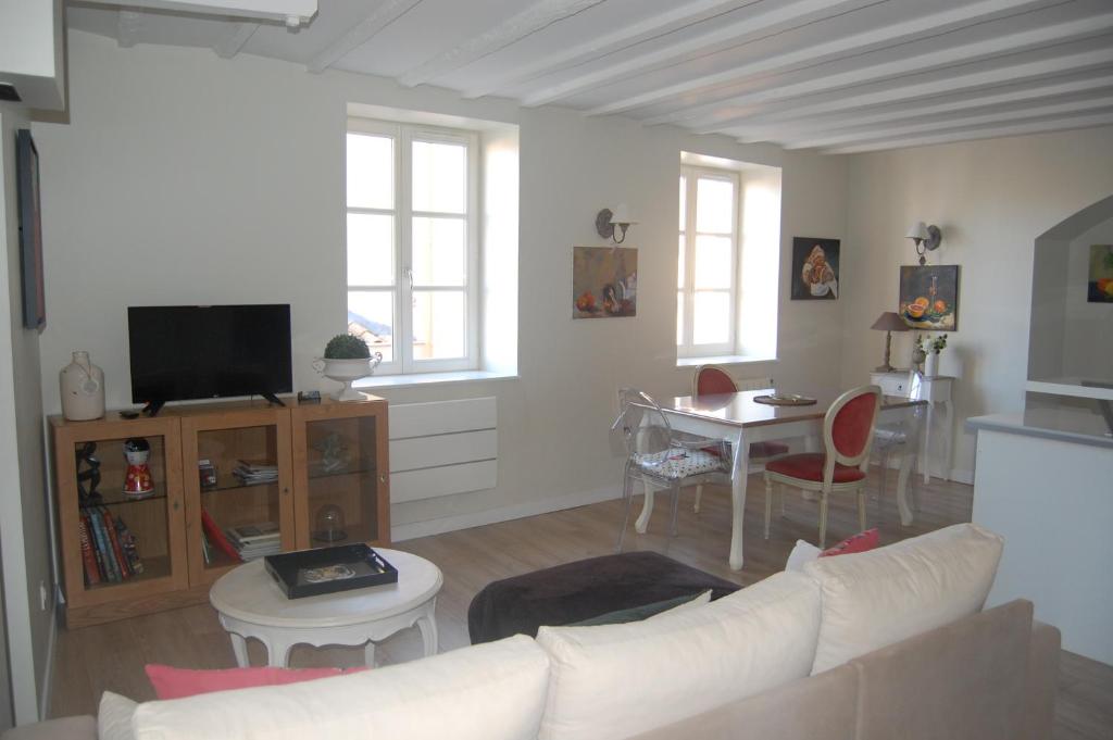 ein Wohnzimmer mit einem weißen Sofa und einem Tisch in der Unterkunft La Maison de Marie in Charnay-lès-Mâcon