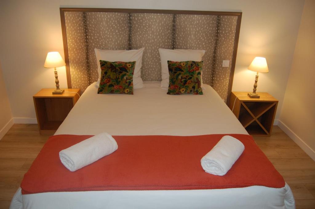 a bedroom with a large white bed with two lamps at La Maison de Marie in Charnay-lès-Mâcon
