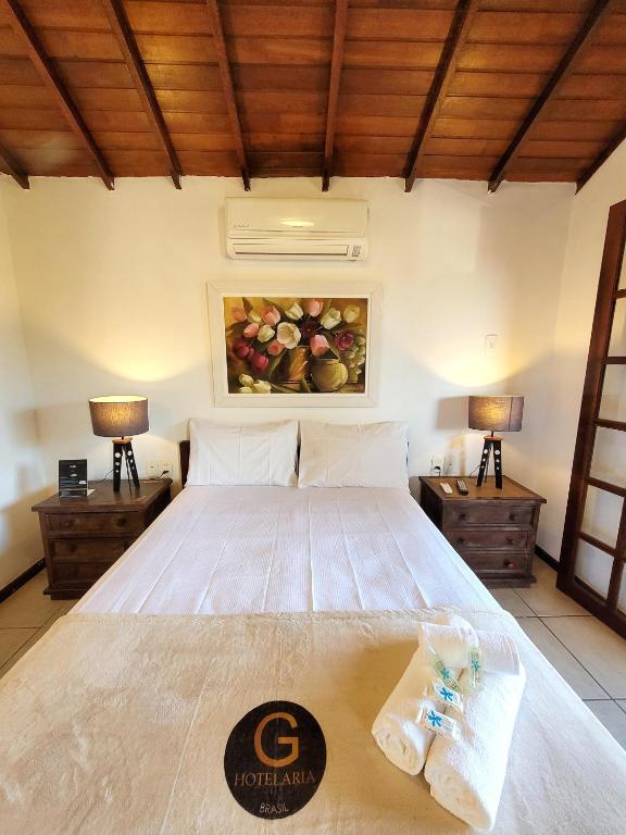 a bedroom with a large bed with two lamps at Pousada Centro Class in Búzios