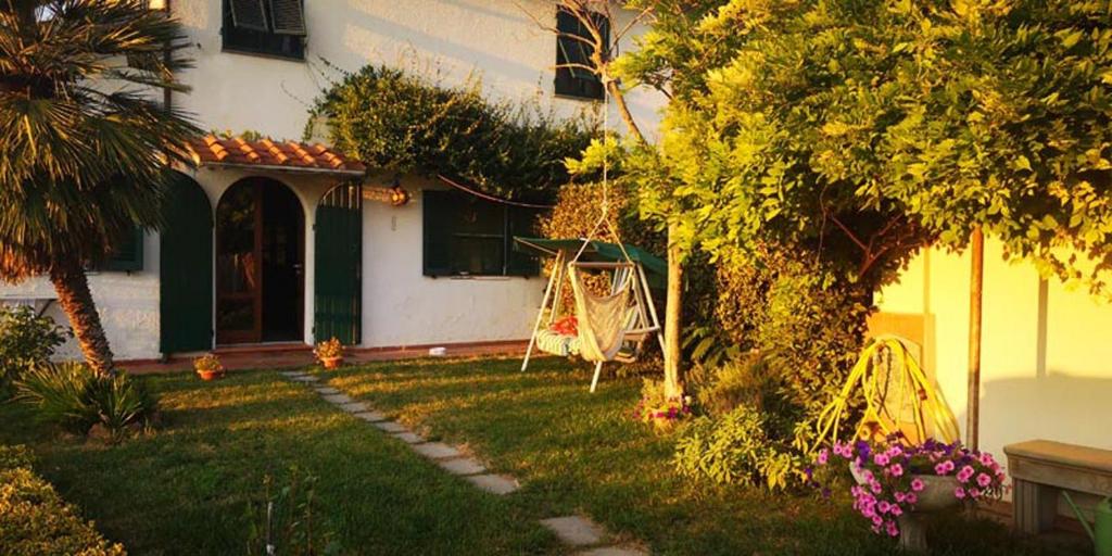 a house with a yard with a swing at Grazioso rustico Toscano in Luciana