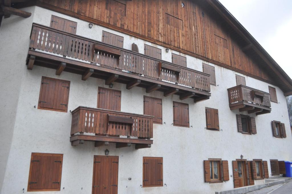 a building with wooden balconies on the side of it at La Casa di Nicky - San Vito di Cadore in San Vito di Cadore