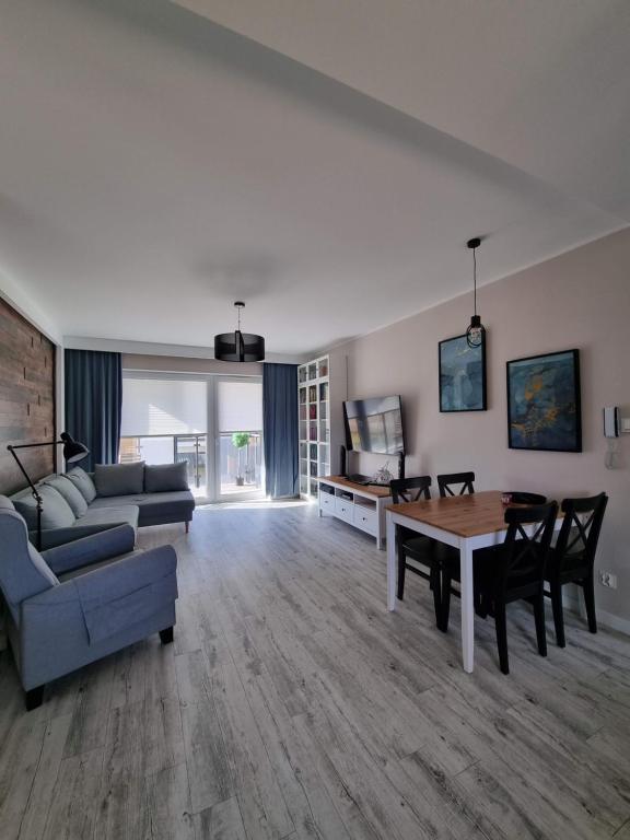 a living room with a couch and a table at Apartament Sosnowy Las in Gdańsk