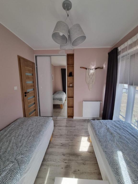 Posteľ alebo postele v izbe v ubytovaní Apartament Sosnowy Las
