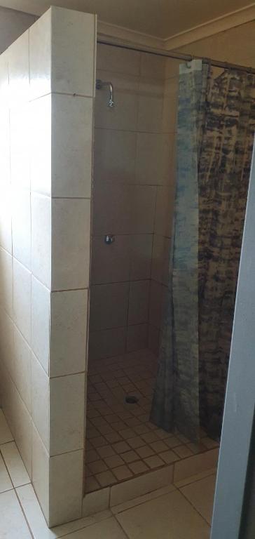 a shower with a glass door in a bathroom at Canada in Kempton Park