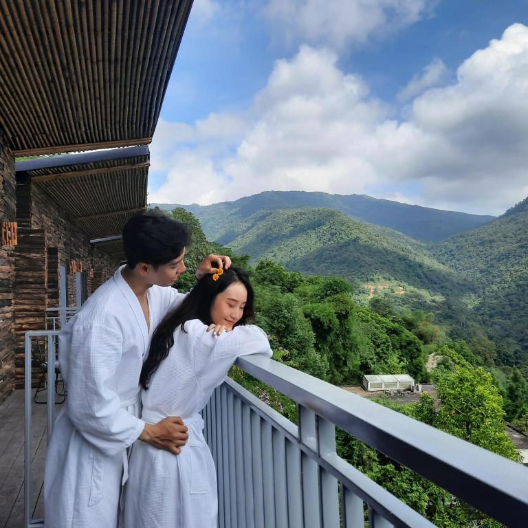 a man and a woman standing on a balcony at The SkyView Villa & Resort in Kệ Sơn