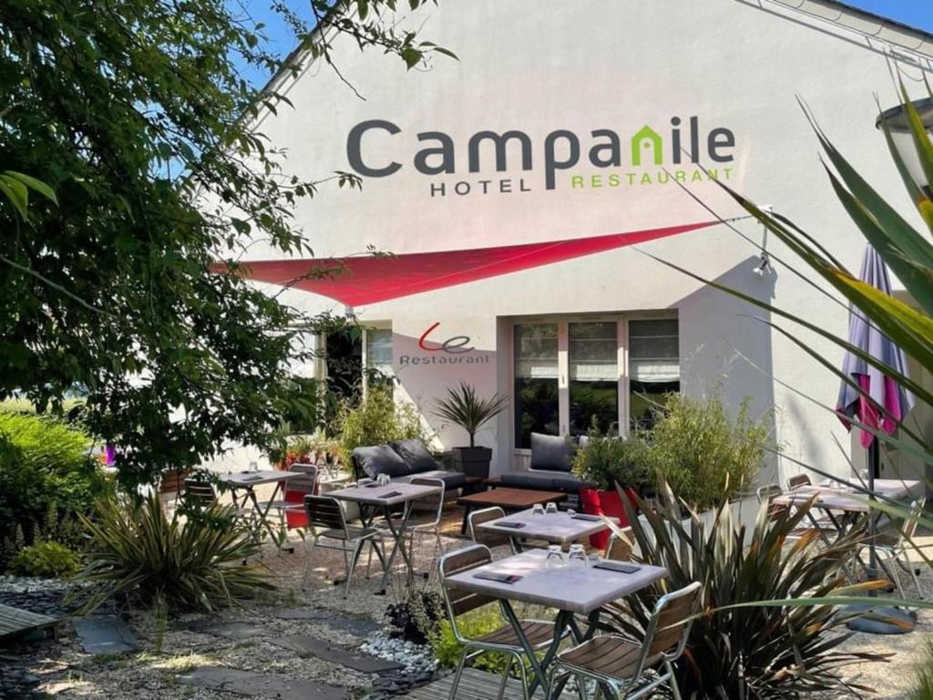 een groep tafels en stoelen voor een gebouw bij Campanile Caen Est - Mondeville in Mondeville
