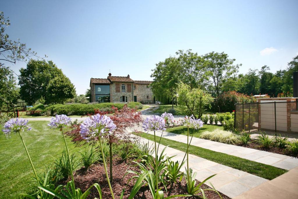 a garden with purple flowers in front of a house at Villa Gourmet in Orentano