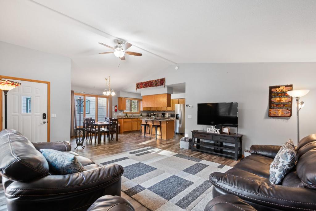 a living room with leather couches and a tv at Coeur d'Alene Cozy in Coeur d'Alene