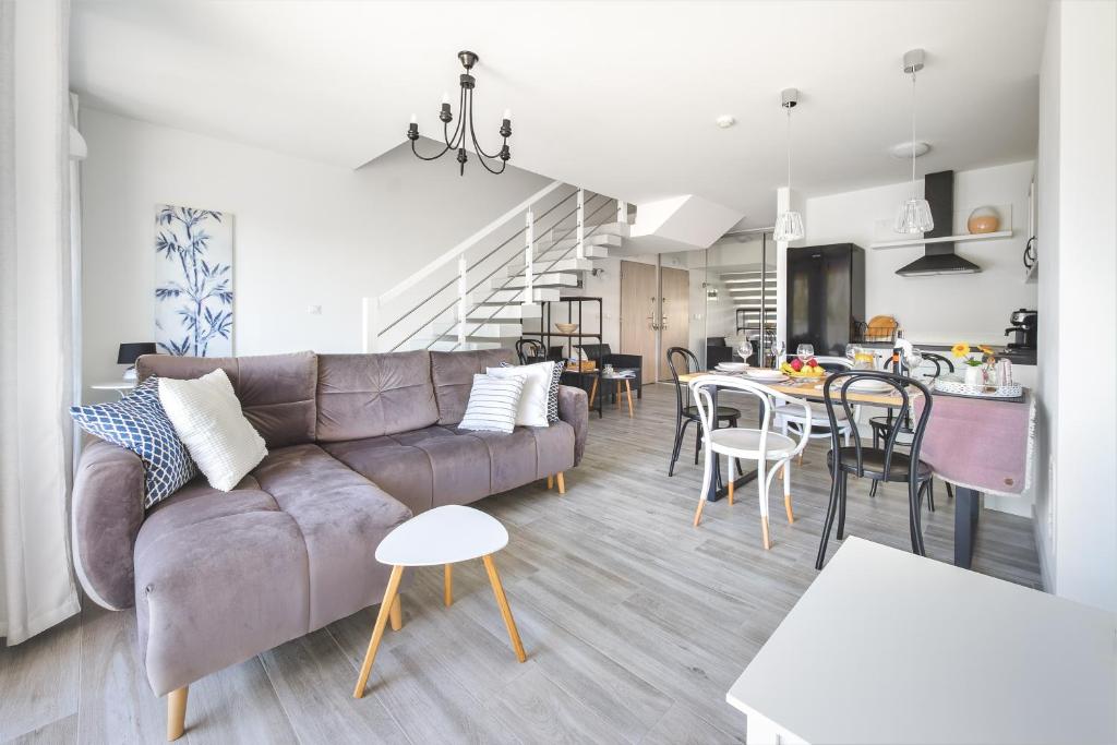 Apartament Lubię Morze في يانتار: غرفة معيشة ومطبخ مع أريكة وطاولة
