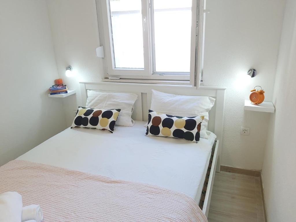 a bedroom with a bed with two pillows and a window at Apartman Nina in Gradac