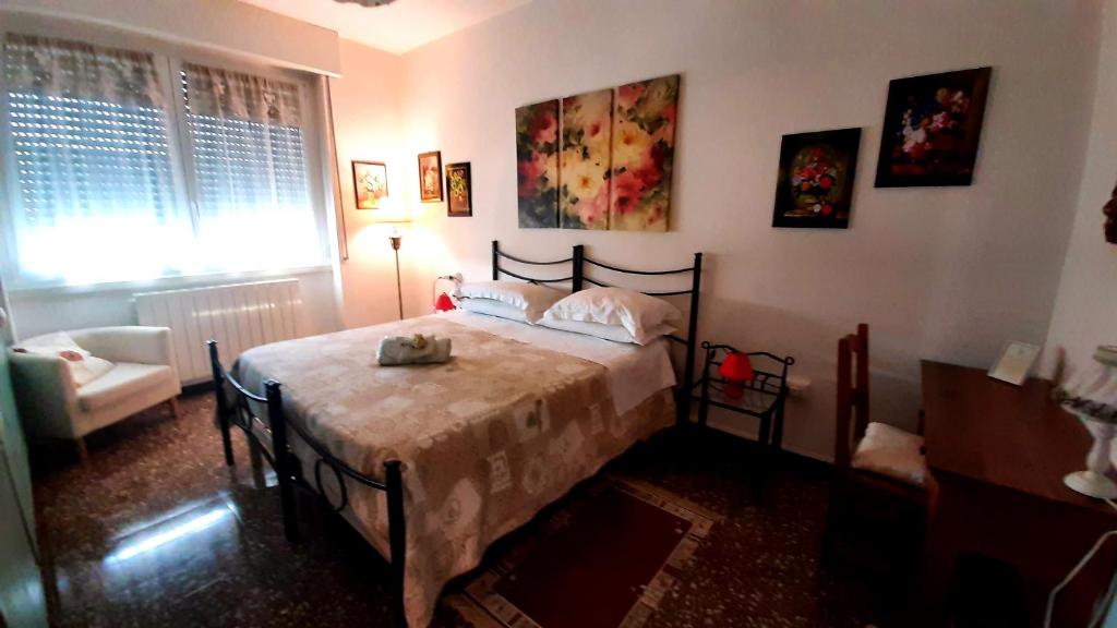 um quarto com uma cama, uma cadeira e uma janela em B&B Rosa em Samarate