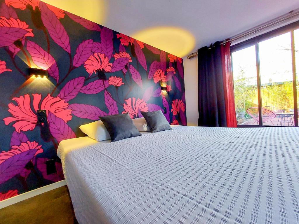 a bedroom with a large bed with a floral wallpaper at Le Huis Clos in Amboise