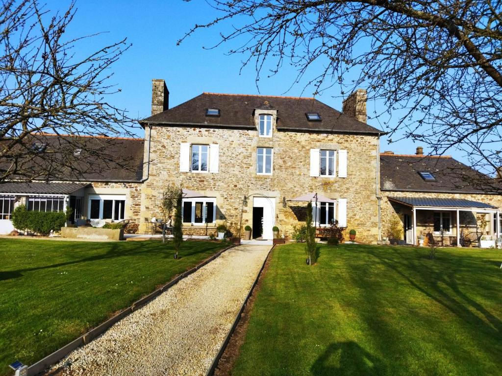 a large stone house with a green lawn at La Ménardière "Tranquilitatis" Chambre double petit déjeuner compris in Corseul