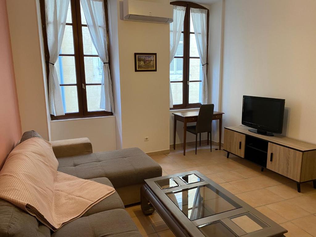uma sala de estar com um sofá e uma televisão em DECOUVERTE DE MARSEILLE em Marselha