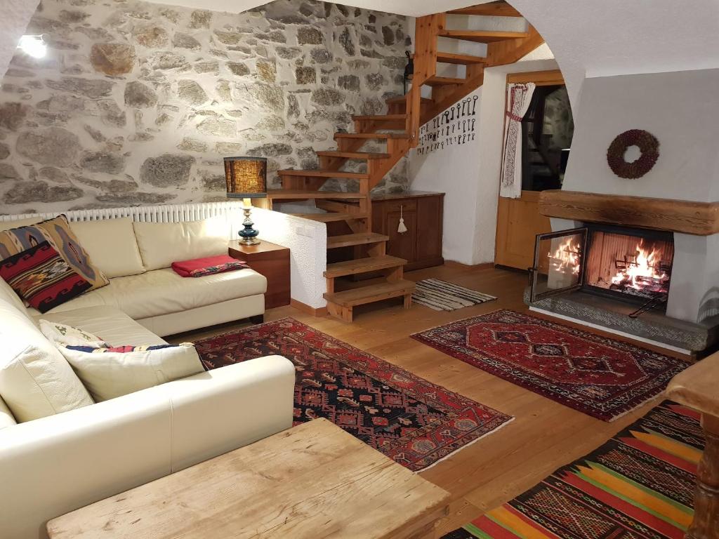 sala de estar con sofá y chimenea en Ronchet Baita Vanoi Trentino, en Ronco