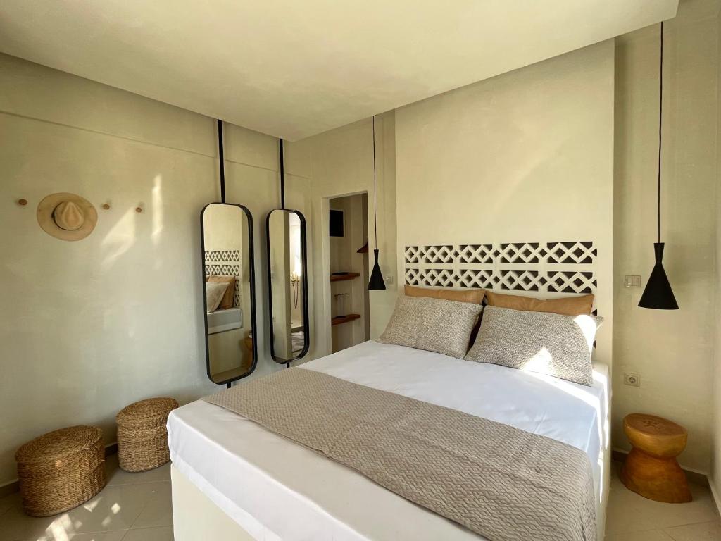 a bedroom with a bed and two mirrors on the wall at Naxian Touch in Agia Anna Naxos