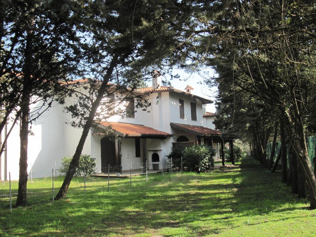 una gran casa blanca con árboles en el primer plano en Viale Algeria 94, en Lido delle Nazioni