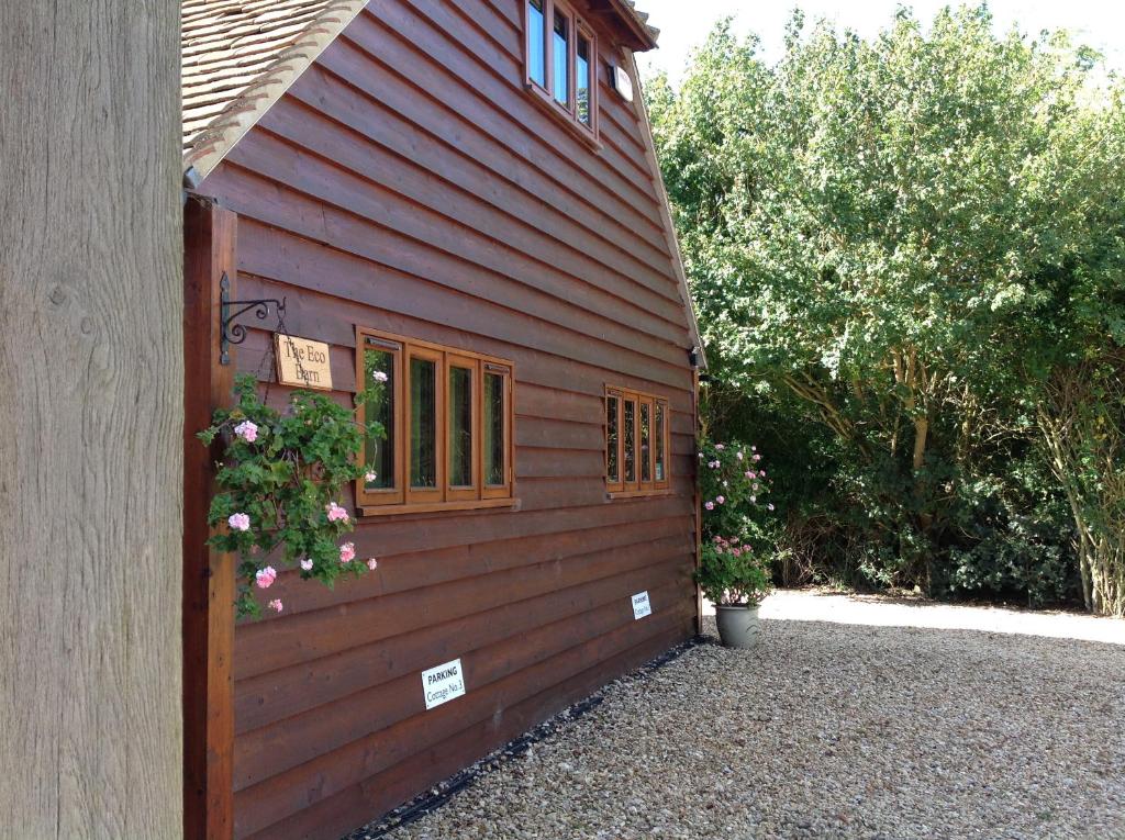 a red building with a window and flowers on it at The Oak Lodge, Clematis Cottages, Stamford in Stamford