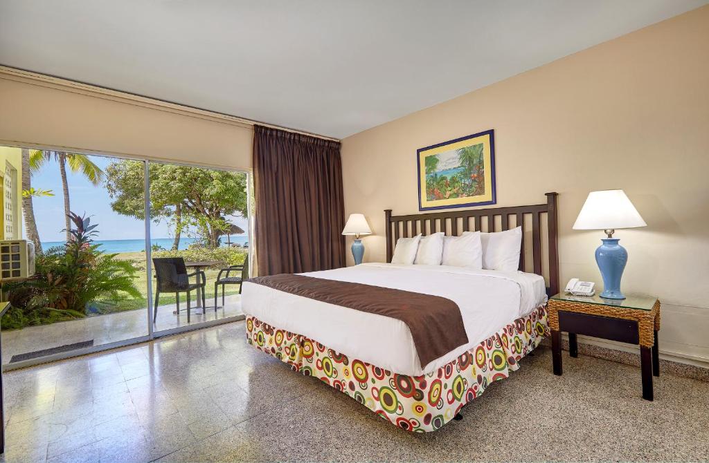 a bedroom with a bed and a view of the ocean at Starfish Tobago in Scarborough