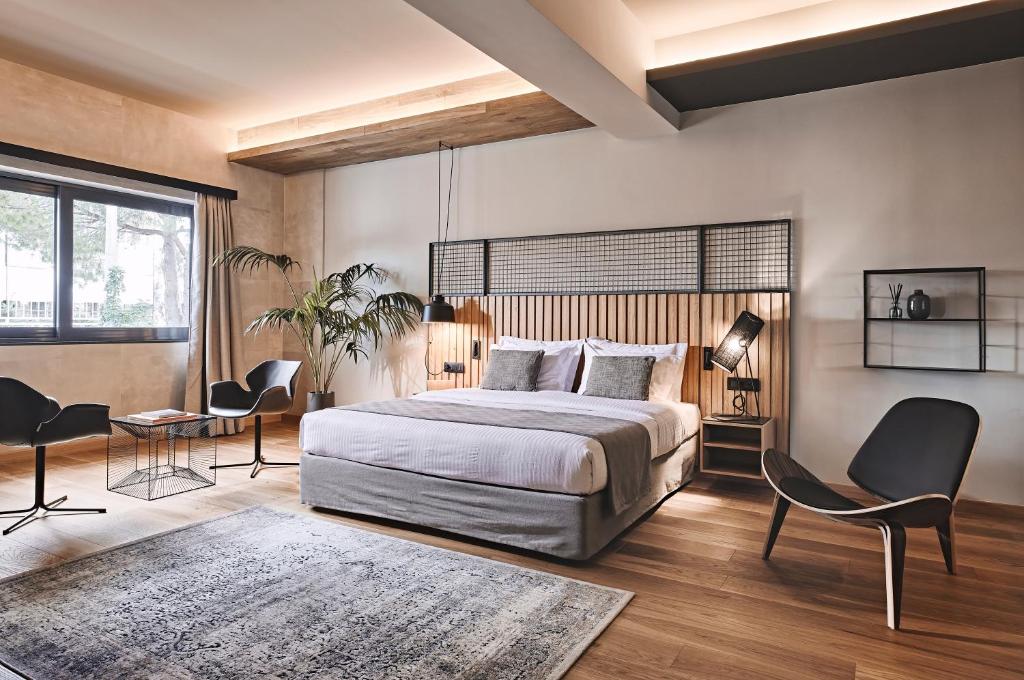 Cama Luxury Suites في أثينا: غرفة نوم بسرير وطاولة وكراسي