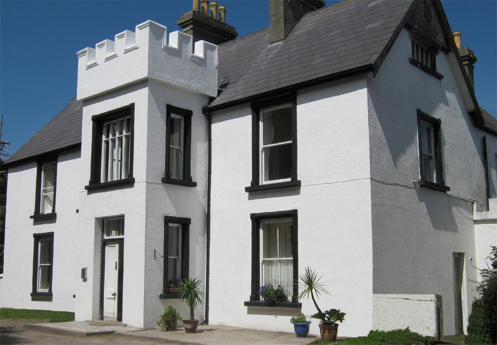 a white house with a black roof at The Valley House in Valley