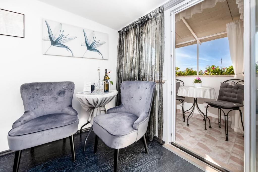 een kamer met twee stoelen, een tafel en een raam bij Studio Apartment Sunce in Rovinj