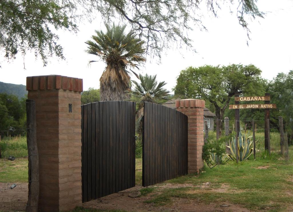 una cerca de madera con un árbol detrás de ella en Cabanas en el Jardin Nativo in 