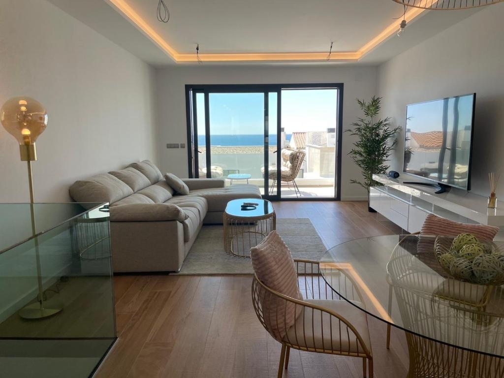 a living room with a couch and a table and chairs at Links II 505 Duplex 2bedroom Apartment GOLF Alcaidesa SPAIN in Alcaidesa