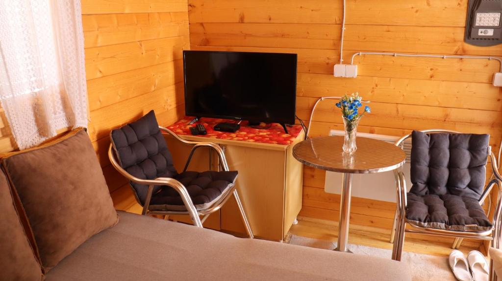 a room with a table and two chairs and a television at Vikendica Mijajlović 2 in Kuršumlija