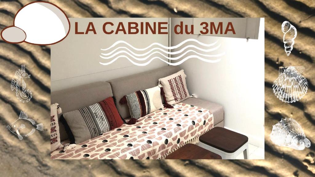 Cartel de un sofá con almohadas en La cabine du 3MA en Lanton